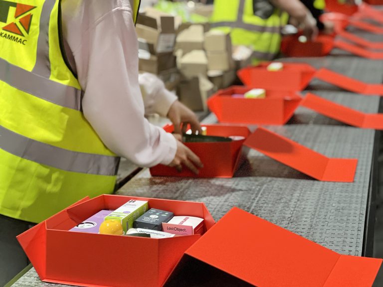 fulfillment staff in process of packing subscription boxes in warehouse