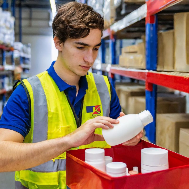 Firefly man in yellow hi-vis not smiling and navy t-shirt packing white beauty products in red box i 1